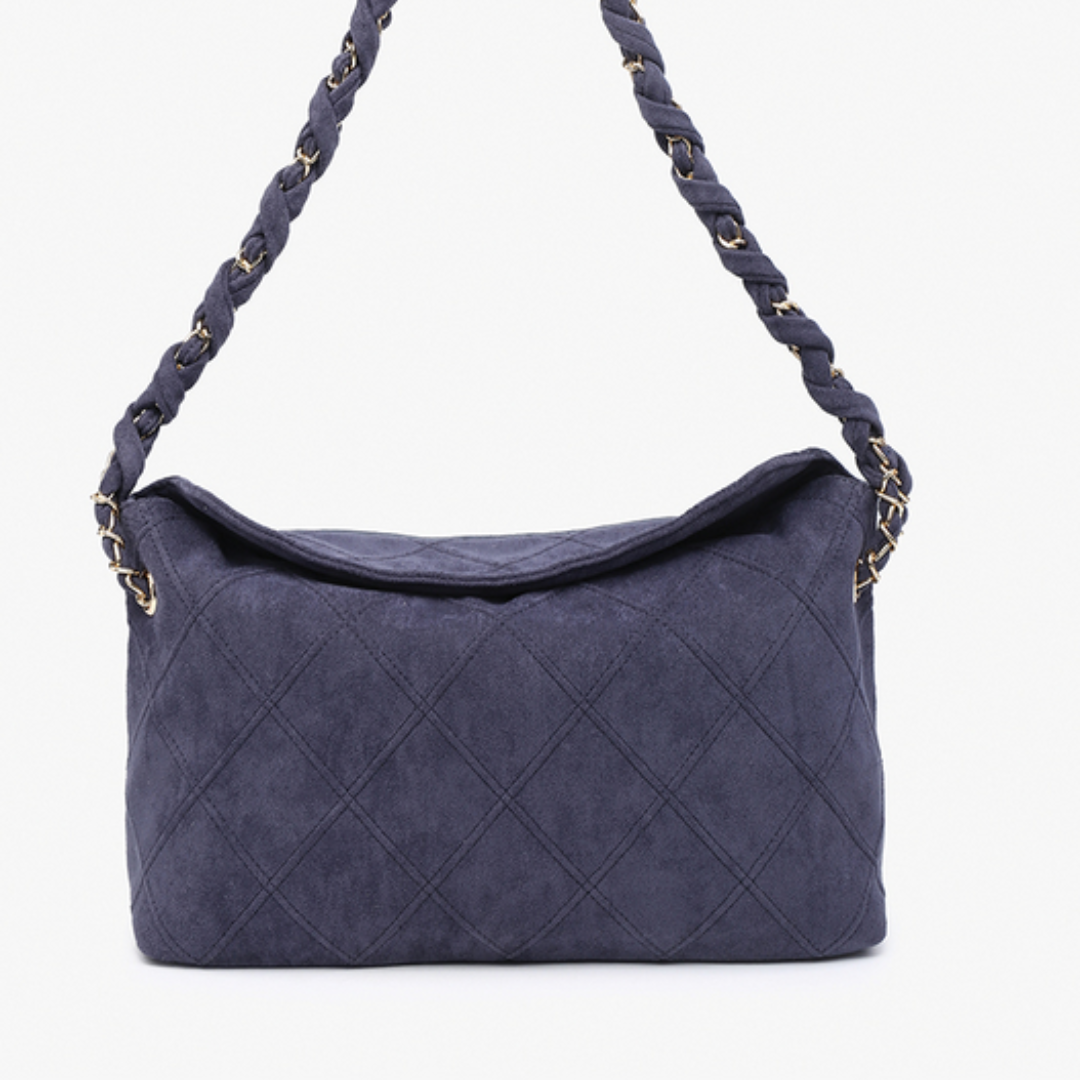 Blue quilted handbag with braided handle on a white background