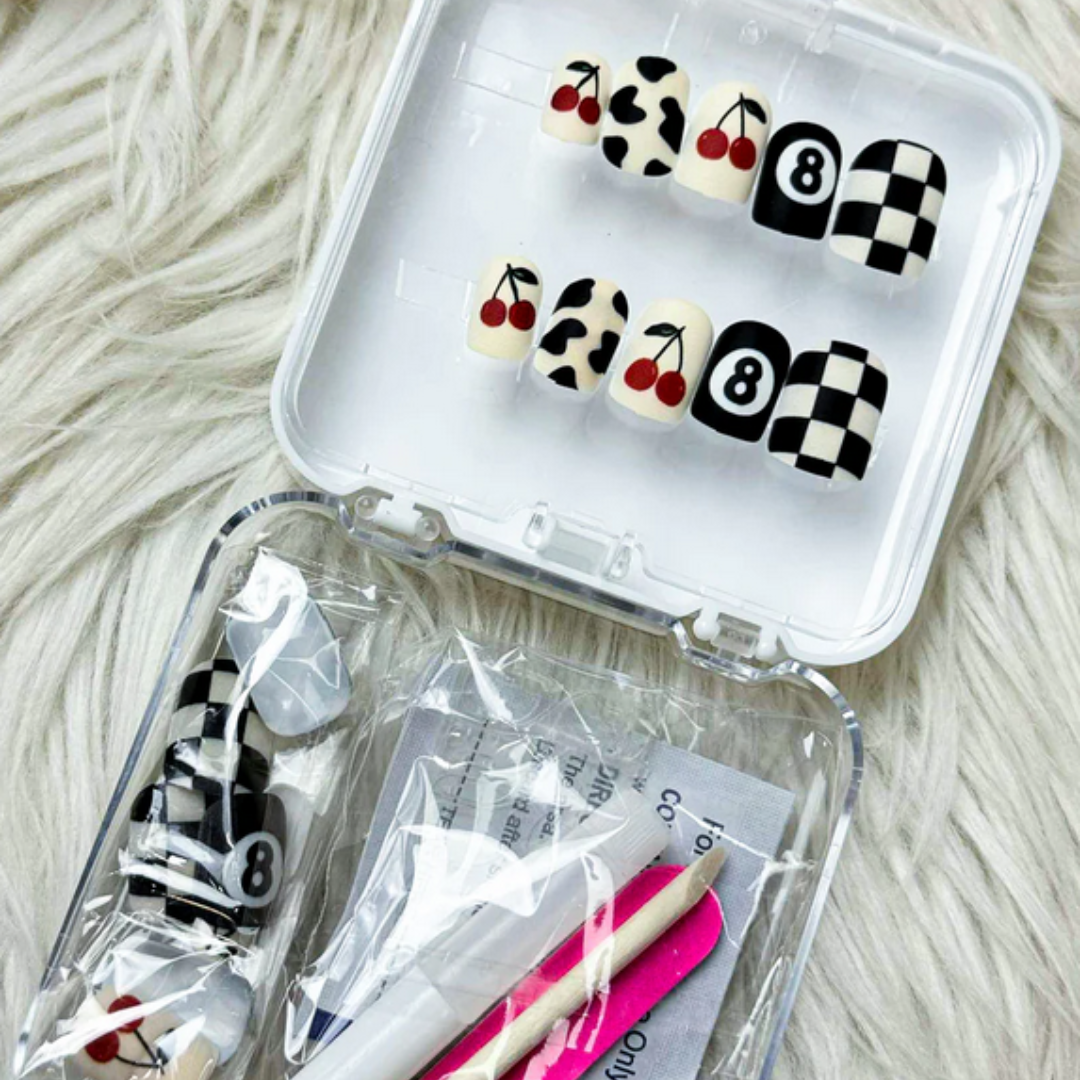 Clear plastic case with nail art tools and designs on a textured surface
