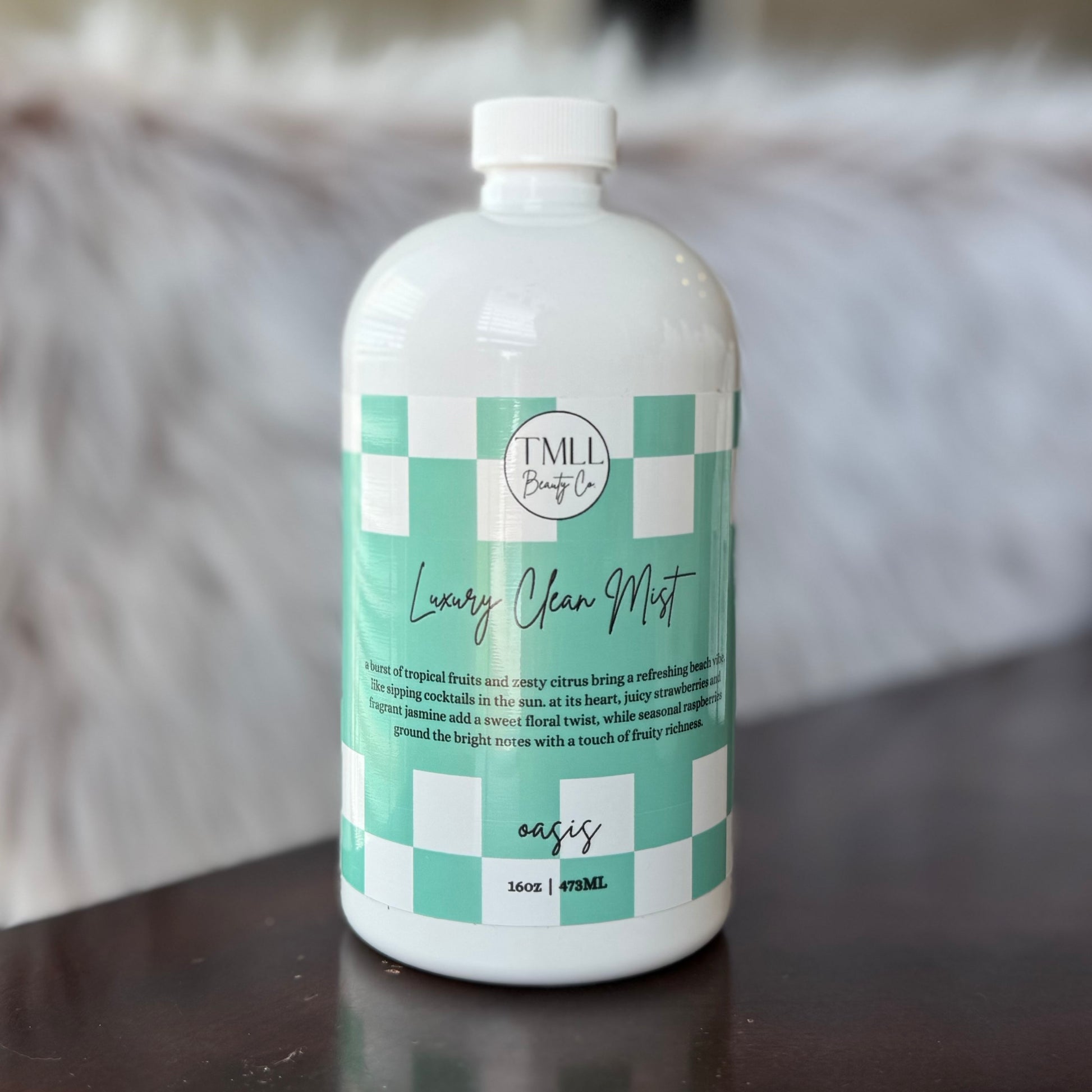 Bottle of Oasis 'Luxury Clean Mist' with a checkered label on a wooden surface