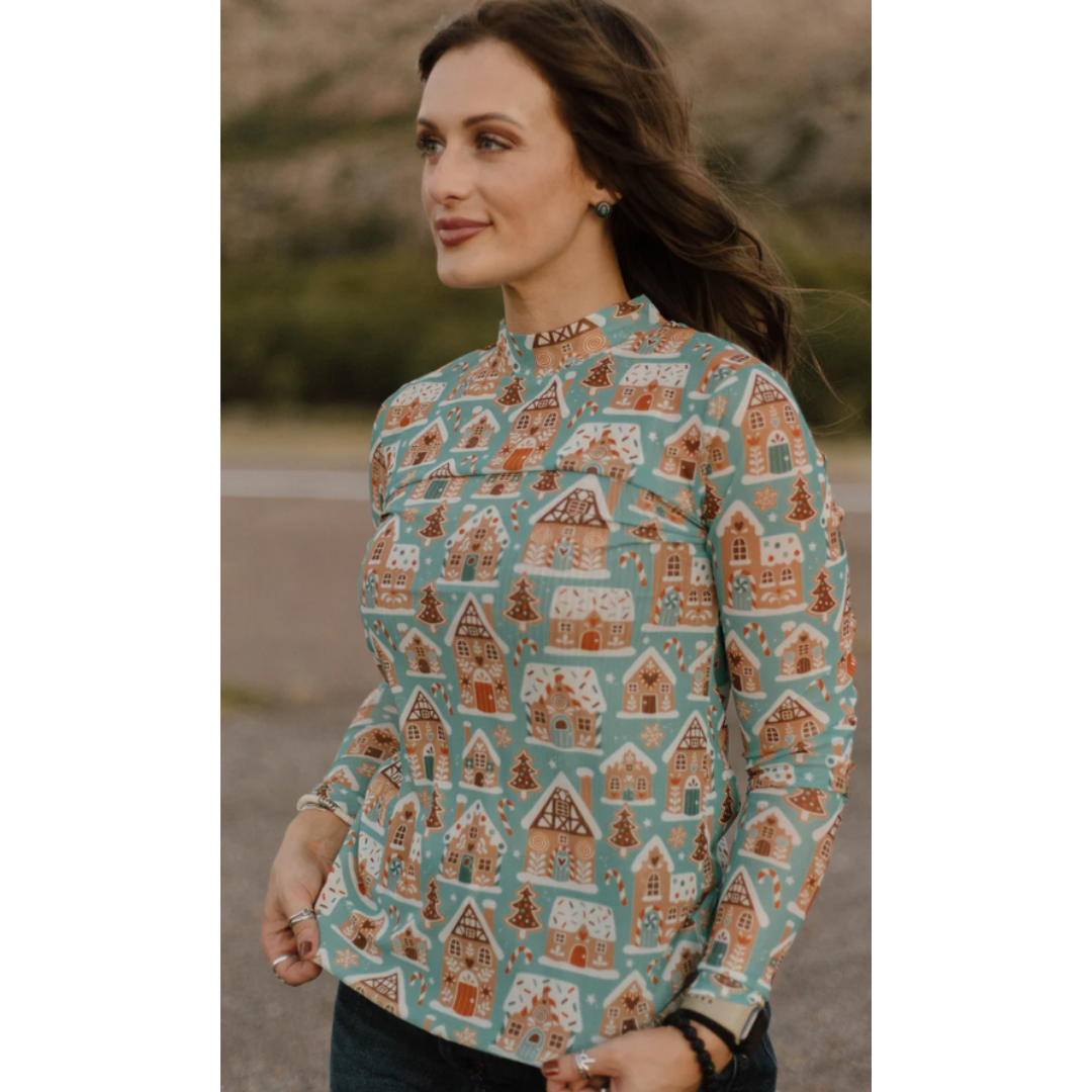Woman wearing a long-sleeve shirt with gingerbread house pattern outdoors