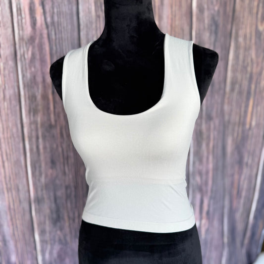 Off white tank top on a mannequin against a wooden background