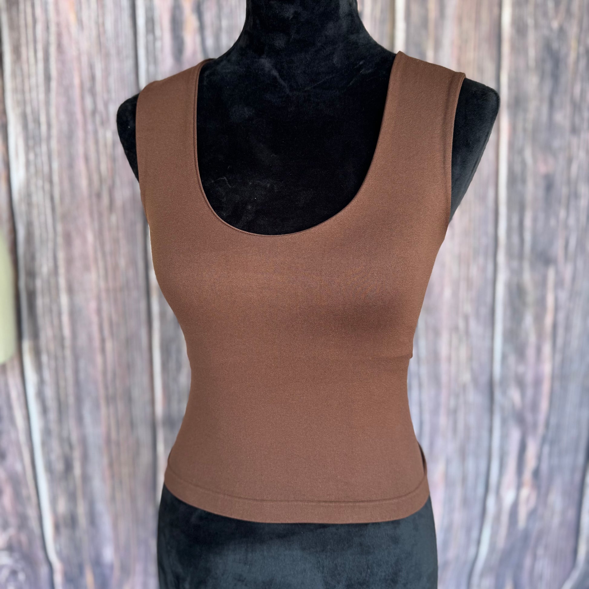 Brown tank top on a mannequin against a wooden background