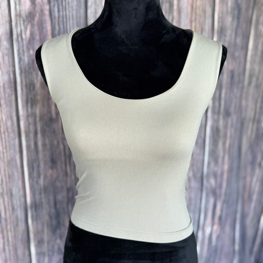 Ash white tank top on a black mannequin against a wooden background